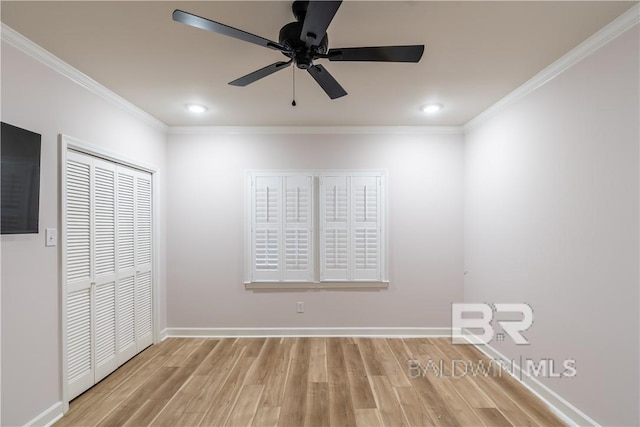 spare room featuring light wood-type flooring, ceiling fan, and crown molding