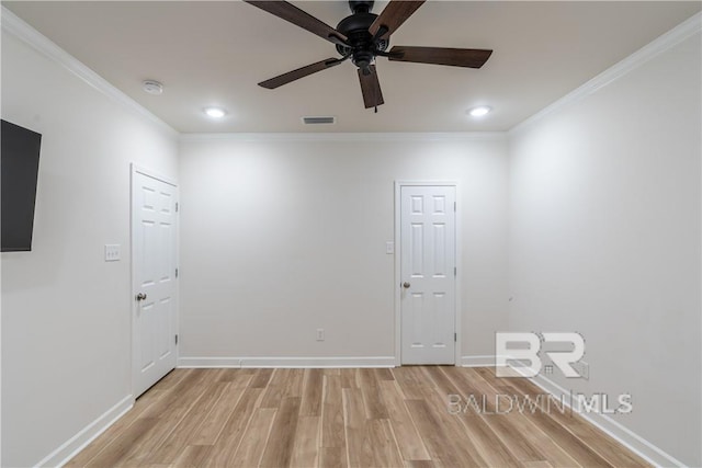 empty room featuring ceiling fan, light wood-type flooring, and crown molding