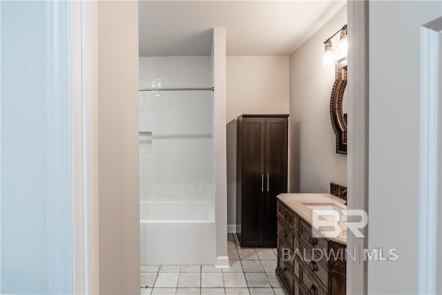 bathroom with a tile shower, tile patterned flooring, and vanity