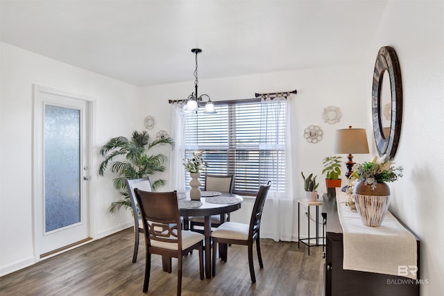 dining space with a chandelier and dark hardwood / wood-style flooring