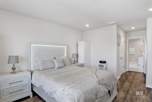 bedroom with ensuite bathroom and dark hardwood / wood-style flooring