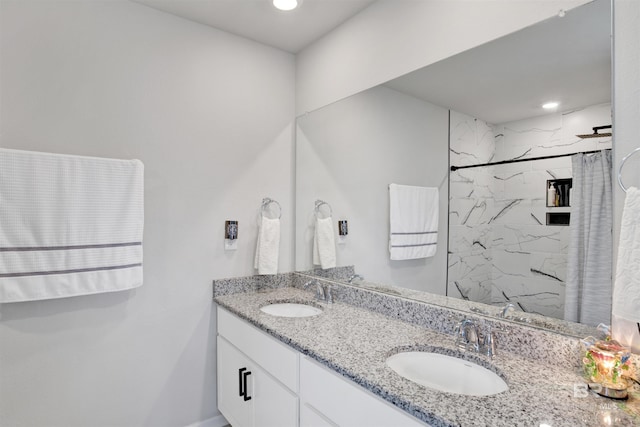 bathroom with tiled shower and vanity