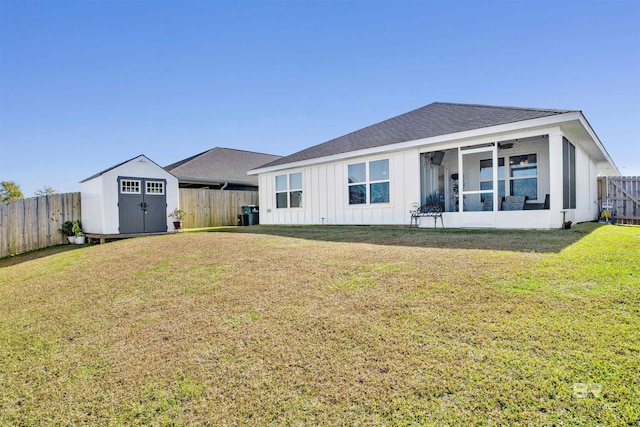 back of property featuring a lawn, ceiling fan, and a storage unit