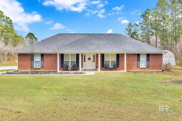 single story home with a shingled roof, a porch, a front yard, and brick siding