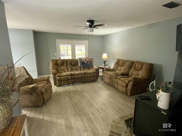 living room with light hardwood / wood-style floors and ceiling fan