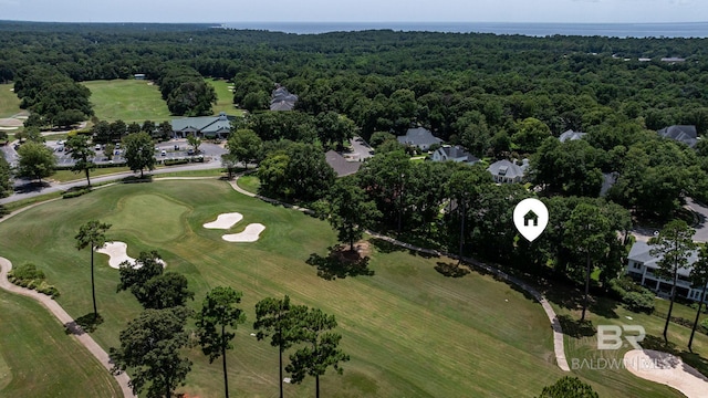 drone / aerial view featuring view of golf course and a wooded view