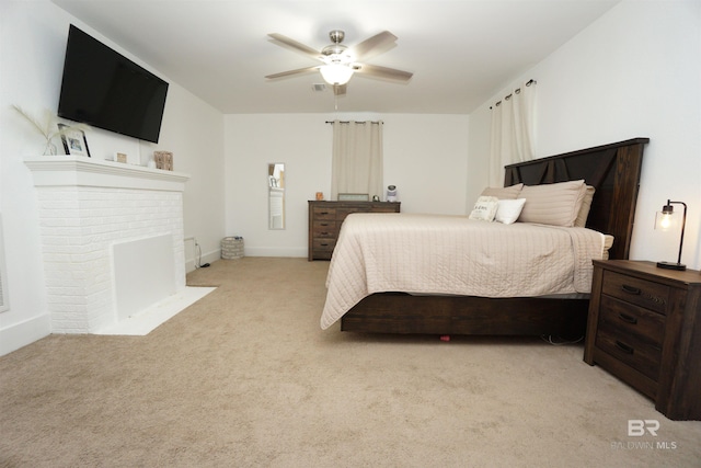 carpeted bedroom featuring a fireplace and ceiling fan