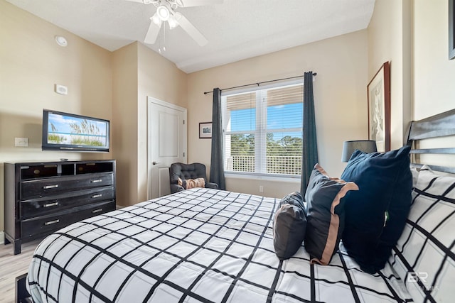 bedroom featuring ceiling fan, light hardwood / wood-style flooring, and a textured ceiling