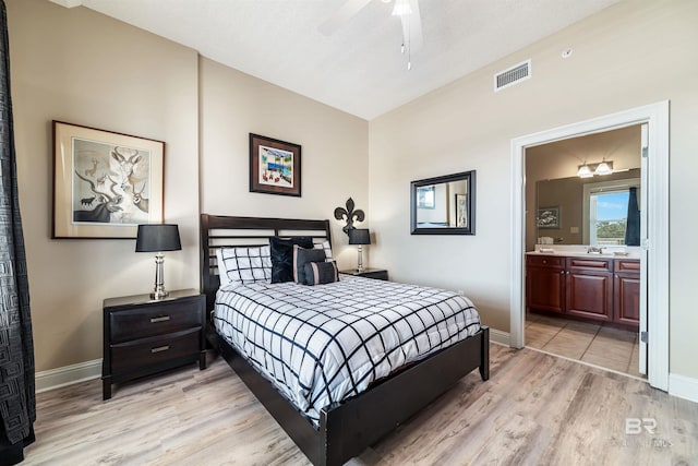 bedroom featuring sink, connected bathroom, and light wood-type flooring