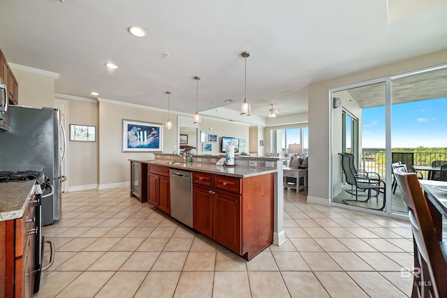 kitchen featuring hanging light fixtures, light tile patterned flooring, appliances with stainless steel finishes, and an island with sink