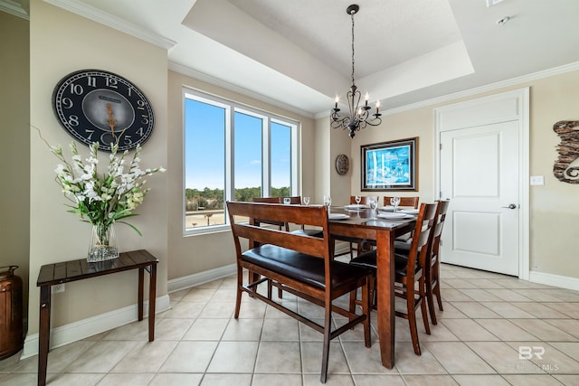 dining area featuring crown molding, a raised ceiling, an inviting chandelier, and light tile patterned floors