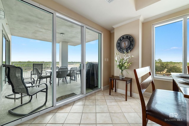 doorway to outside with light tile patterned floors, crown molding, and a wealth of natural light