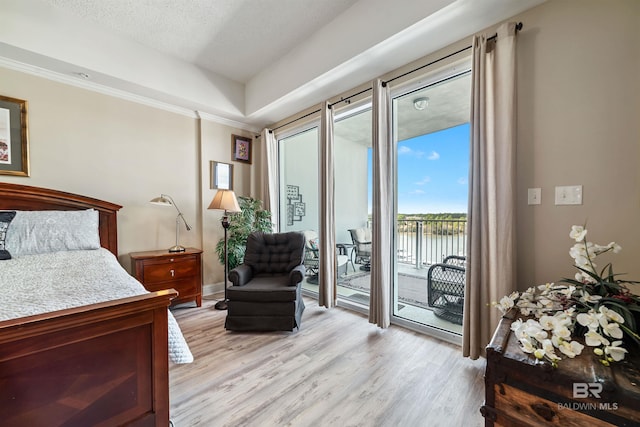 bedroom with crown molding, access to outside, light hardwood / wood-style floors, and a textured ceiling