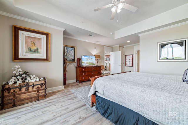 bedroom with ornamental molding, a tray ceiling, ceiling fan, and light hardwood / wood-style flooring