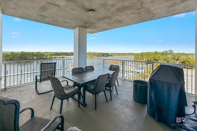view of patio / terrace with a balcony, a water view, and area for grilling