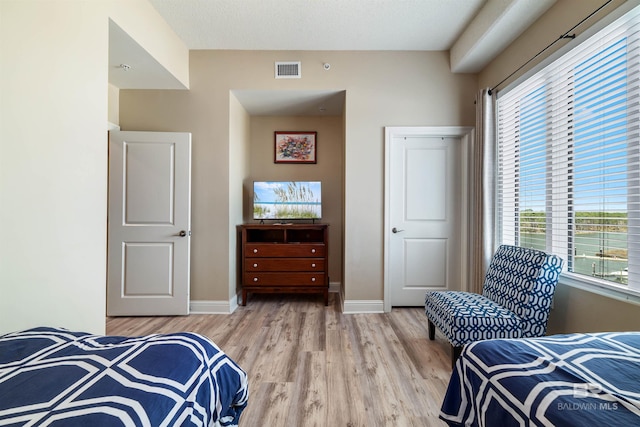 bedroom with a textured ceiling and light hardwood / wood-style floors