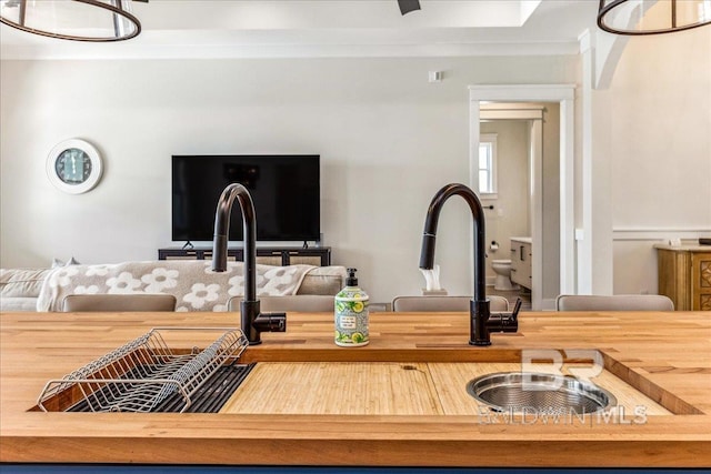 kitchen with open floor plan, butcher block counters, and ornamental molding