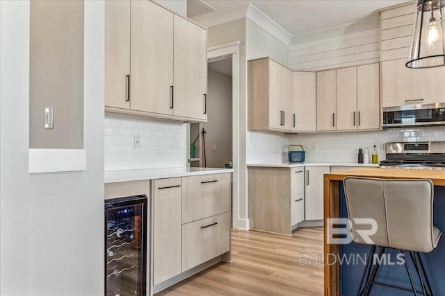 kitchen featuring light countertops, beverage cooler, light brown cabinets, stainless steel appliances, and light wood-style floors