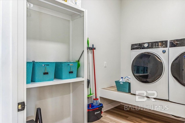 washroom featuring independent washer and dryer, laundry area, and wood finished floors