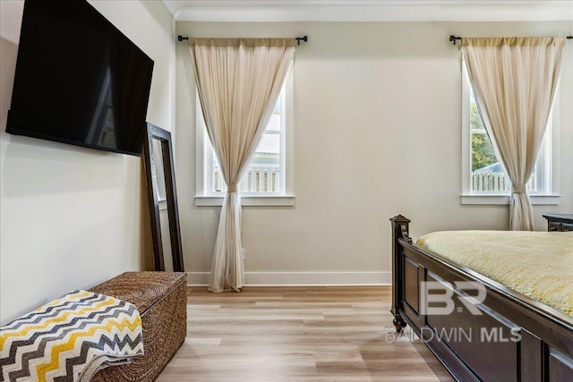 bedroom with baseboards and light wood-type flooring