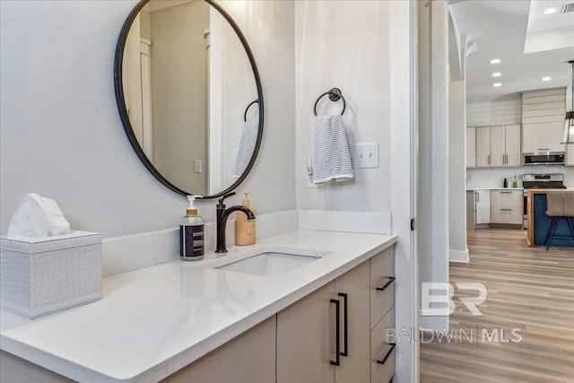bathroom featuring backsplash, vanity, recessed lighting, and wood finished floors