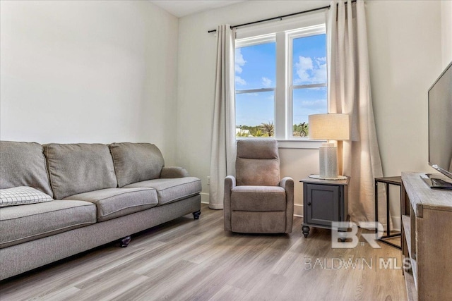 living area with baseboards and light wood finished floors