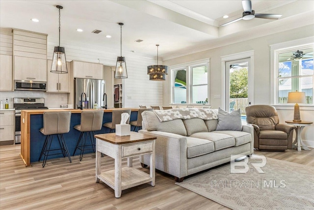 living area featuring visible vents, crown molding, light wood finished floors, ceiling fan, and recessed lighting