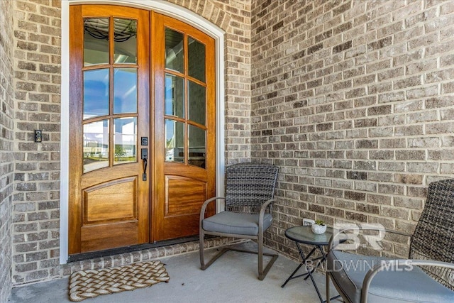 doorway to property featuring brick siding and french doors