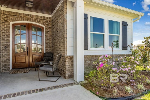 property entrance with brick siding and french doors