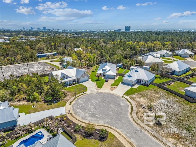 drone / aerial view featuring a residential view and a wooded view