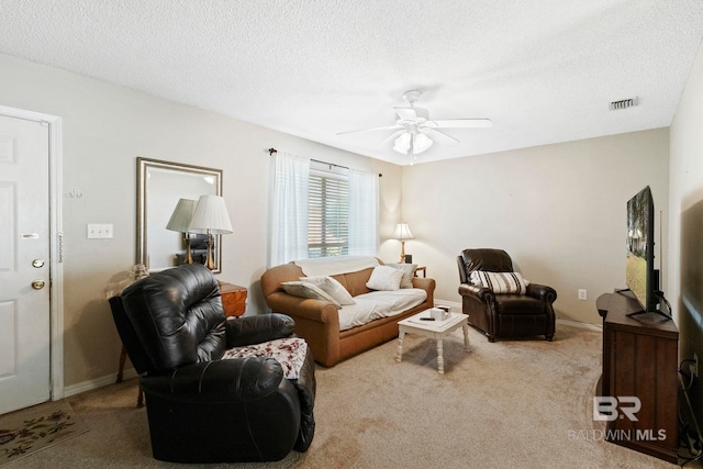 living room with a textured ceiling, ceiling fan, and light carpet