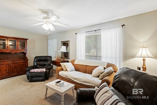 living room with a textured ceiling, carpet floors, and ceiling fan