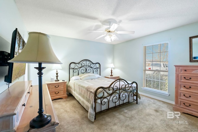 carpeted bedroom with ceiling fan and a textured ceiling