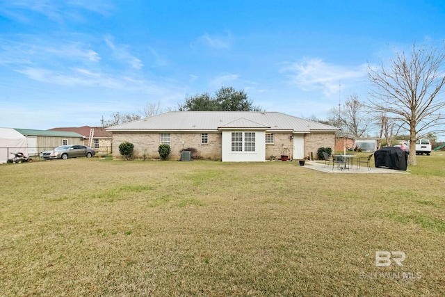 rear view of house featuring a patio, central air condition unit, and a lawn