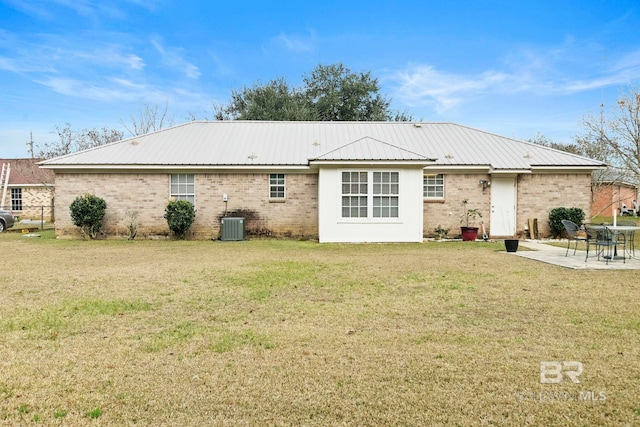 rear view of house with cooling unit, a patio area, and a yard