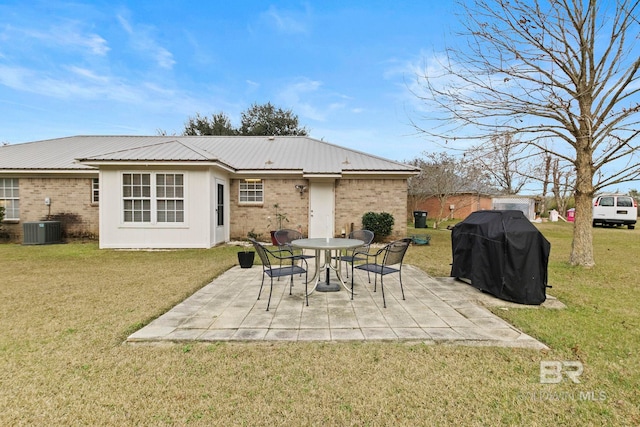 rear view of house with a patio area, a yard, and central AC