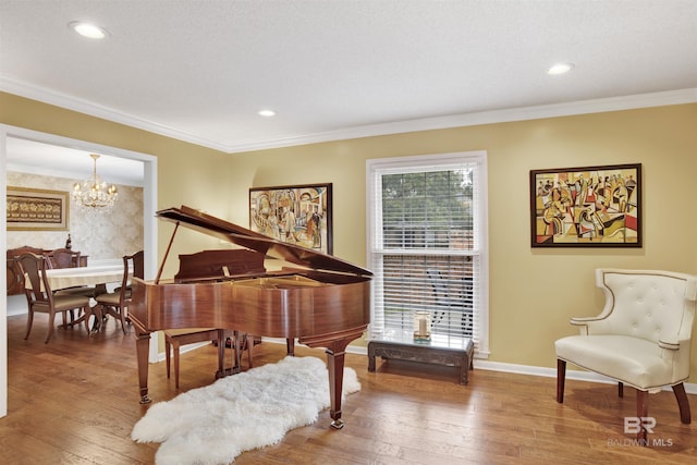 living area with a notable chandelier, wood-type flooring, and crown molding