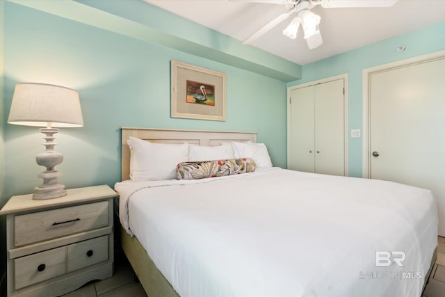 bedroom with a closet, ceiling fan, and tile patterned flooring