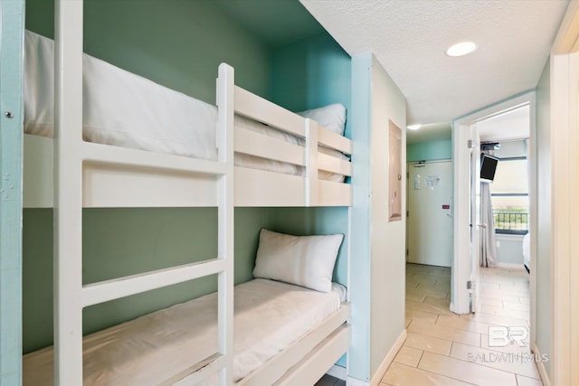 tiled bedroom featuring a textured ceiling