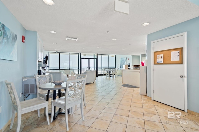 tiled dining area with floor to ceiling windows and a textured ceiling