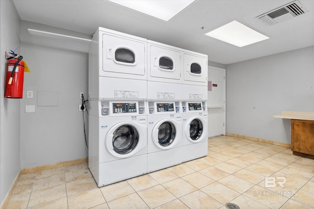 laundry area featuring washer and clothes dryer, light tile patterned flooring, and stacked washer / drying machine