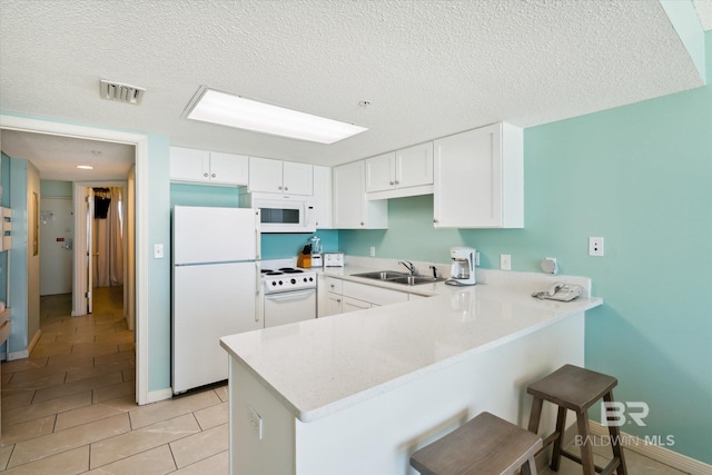 kitchen featuring kitchen peninsula, white appliances, white cabinetry, and sink