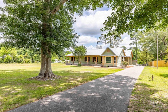 view of front of house with fence, a front yard, and aphalt driveway