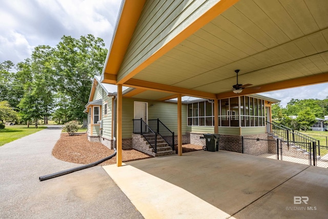 view of patio / terrace featuring a ceiling fan, an attached carport, and fence
