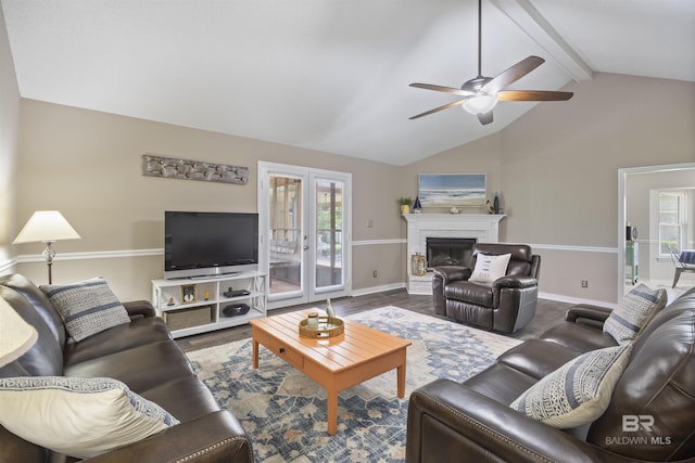 living area with a ceiling fan, baseboards, wood finished floors, a fireplace, and vaulted ceiling with beams