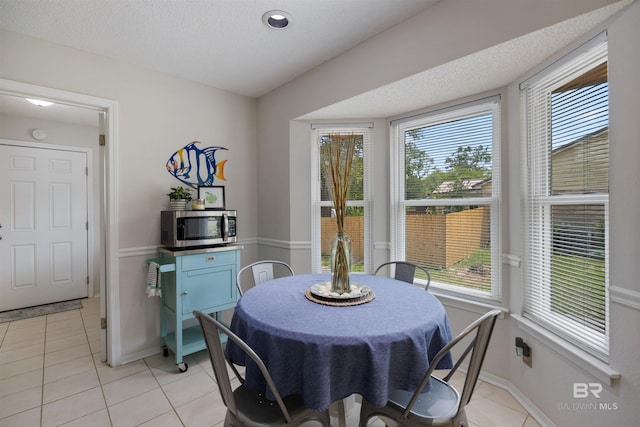 dining room with baseboards, light tile patterned floors, and plenty of natural light