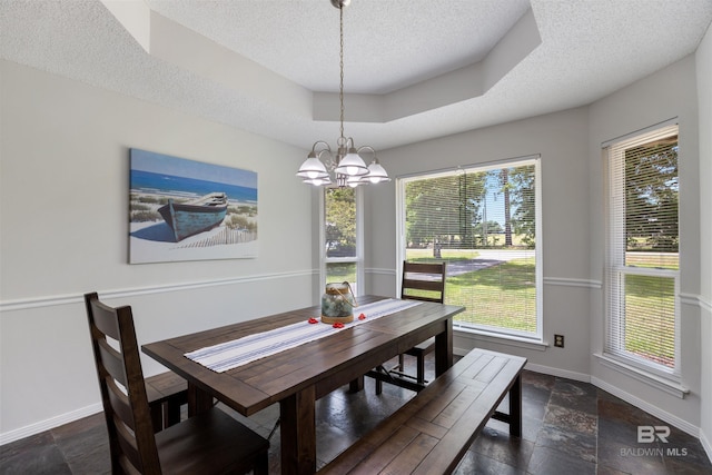 dining space featuring baseboards, plenty of natural light, a textured ceiling, and stone tile flooring