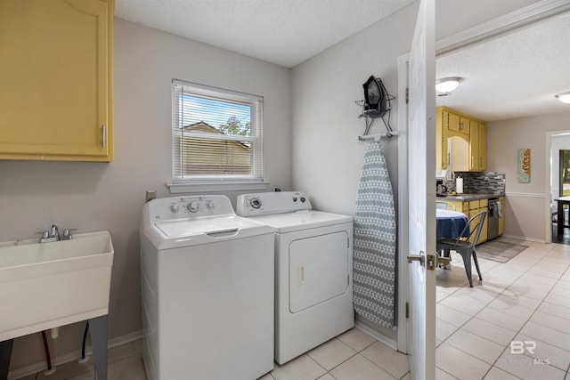 washroom featuring a sink, separate washer and dryer, cabinet space, and a healthy amount of sunlight