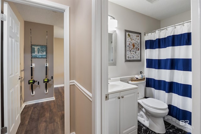 full bathroom featuring toilet, wood finished floors, vanity, curtained shower, and a textured ceiling