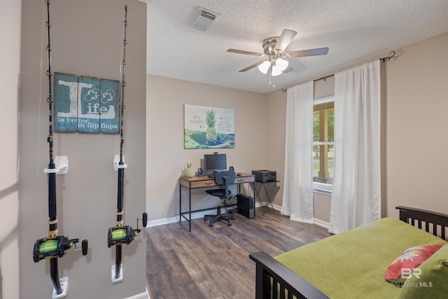 bedroom with a textured ceiling, visible vents, dark wood-style flooring, and baseboards